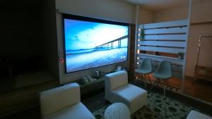 ein Wohnzimmer mit einem großen TV und Stühlen in der Unterkunft Yurihonjo - Hotel - Vacation STAY 42543v in Yurihonjo