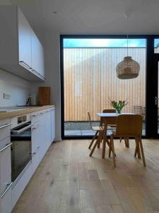 a kitchen with a table and a dining room at Ruhige Lage - Moderne Ferienwohnung mit Innenhof in Brohl-Lützing