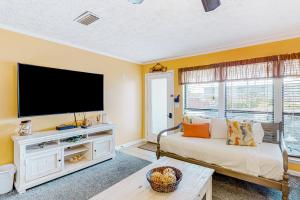 uma sala de estar com uma grande televisão de ecrã plano em Southwinds III - H2 em Panama City Beach