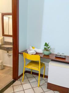 a yellow chair sitting in front of a desk at Hotel Solar in Salinópolis