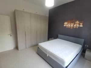 - une chambre avec un lit blanc et une armoire dans l'établissement Appartamento F e F, à Piombino