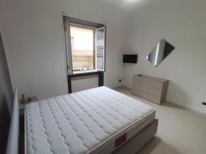 - une chambre blanche avec un lit et une fenêtre dans l'établissement Appartamento F e F, à Piombino