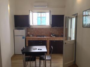 a small kitchen with a table and a refrigerator at Casa Petra - Mini Open Space in Brindisi