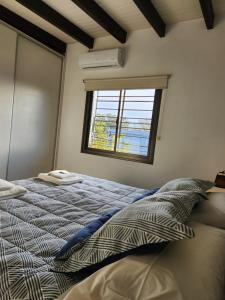a bedroom with a bed and a window at Apartamento Deluxe Senderos del Vino II, desayuno Opcional in Mendoza