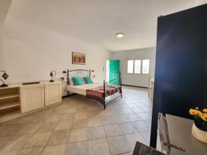 a bedroom with a bed and a tiled floor at COZY STUDIO CLOSE TO THE BEACH! in Santa Maria