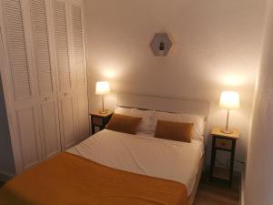 1 dormitorio con 1 cama y 2 lámparas en 2 mesas en Les studios de Marie, en Aviñón