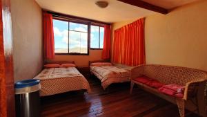 a room with two beds and a window at Korilazos in Cusco
