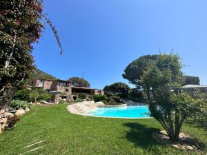 a swimming pool in the middle of a yard at Hôtel Ambassador Palombaggia in Porto-Vecchio
