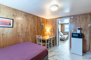 a bedroom with a bed and a table and a kitchen at Boardwalk Sand & Surf Beach Hotel Oceanfront in Seaside Heights
