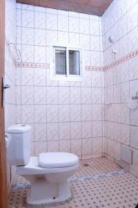 a bathroom with a white toilet and a window at Appart meuble Jouvence chez Chantal & Francis in Yaoundé