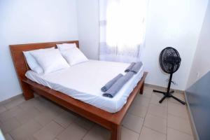 a bedroom with a bed with a fan and a window at Appart meuble Jouvence chez Chantal & Francis in Yaoundé