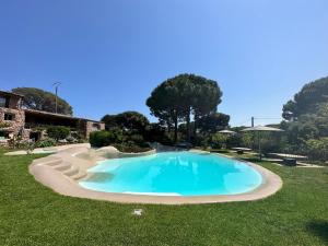 a swimming pool in the middle of a yard at Hôtel Ambassador Palombaggia in Porto-Vecchio