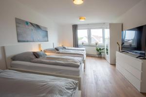 a bedroom with two beds and a flat screen tv at City-House-Achern in Achern