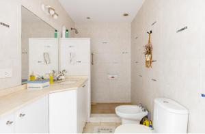 Baño blanco con aseo y lavamanos en Habitación con baño privado Regis Haus en Villa Adelina