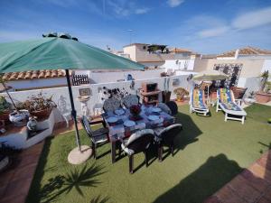 eine Terrasse mit einem Tisch, Stühlen und einem Sonnenschirm in der Unterkunft Altomar2, Gran Alacant, Alicante in Gran Alacant