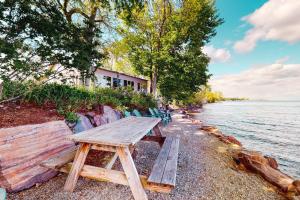 a wooden picnic table on the shore of a lake at Hazen's Hideaway in North Hero