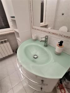 La salle de bains blanche est pourvue d'un lavabo et d'un miroir. dans l'établissement Appartamento F e F, à Piombino