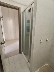 La salle de bains est pourvue d'une cabine de douche avec une porte en verre. dans l'établissement Appartamento F e F, à Piombino