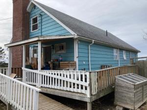 a blue house with a porch and a wooden deck at La Maison Mavillette The Mavillette house 2BD in Mavillette