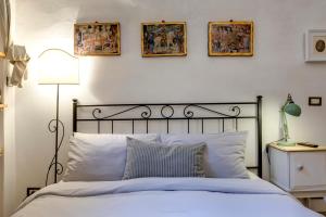 フィレンツェにあるFlorence Holiday Homes Ponte Vecchioのベッドルーム1室(壁に3枚の写真が飾られたベッド1台付)
