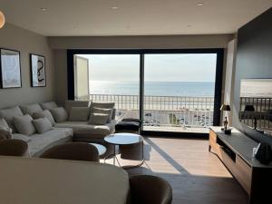 uma sala de estar com um sofá e vista para o oceano em Résidence le Concorde em Le Touquet-Paris-Plage