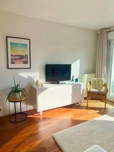 a living room with a white entertainment center with a flat screen tv at Le cocon chaleureux in Vannes