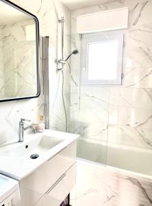 a white bathroom with a sink and a shower at Le cocon chaleureux in Vannes
