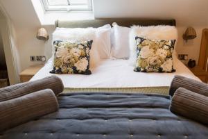 1 dormitorio con 1 cama con sofá y almohadas en The Forge - Beautiful Contemporary Barn - Hot Tub, en Bridgnorth