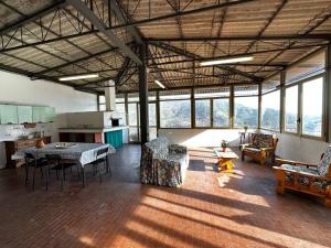 a large room with a table and chairs and windows at Tra le Alpi Apuane e il mare in Montignoso