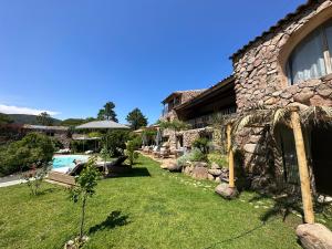 a house with a yard with a swimming pool at Hôtel Ambassador Palombaggia in Porto-Vecchio