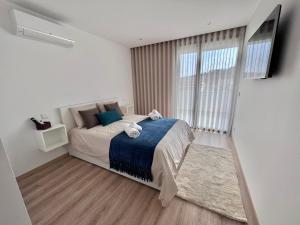 ein Schlafzimmer mit einem Bett und einem großen Fenster in der Unterkunft Castelo View in Pombal