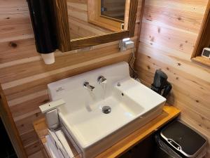 a bathroom with a white sink and a mirror at Kaburo no Niwa Grand Campsite - Vacation STAY 98272v in Matsukawa