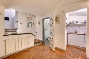a kitchen with white cabinets and a door to a bathroom at Florence Holiday Homes Ponte Vecchio in Florence +22 photos