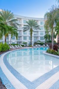 a large swimming pool with palm trees and a building at Meliá Orlando Celebration in Orlando