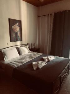 a bedroom with a bed with two shoes on it at Guesthouse Adonis in Kato Loutraki