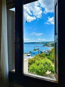 una ventana con vistas al océano desde una casa en Vasilikos Apartments en Paralia Agias Foteinis
