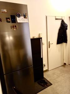 Cette chambre dispose d'une porte et d'un réfrigérateur en acier inoxydable. dans l'établissement Karlin Cozy Studio, à Prague