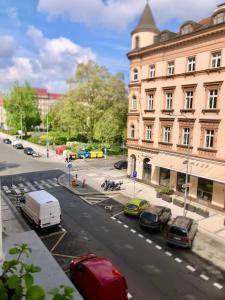 una calle de la ciudad con coches aparcados frente a un edificio en Karlin Cozy Studio en Praga