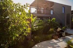 two people sitting in front of a house at Domes Zeen Chania, a Luxury Collection Resort, Crete in Kato Daratso