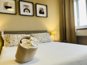 a basket of towels is sitting on a bed at Le Dimore del Corso in Catania