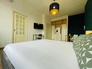 a bedroom with a large white bed and a tv at Le Dimore del Corso in Catania
