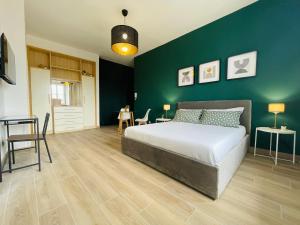 a bedroom with a bed and a green wall at Le Dimore del Corso in Catania