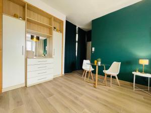 a kitchen with a table and chairs and a green wall at Le Dimore del Corso in Catania