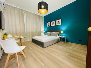1 dormitorio con cama y pared azul en Le Dimore del Corso, en Catania