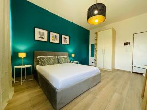 a bedroom with a bed and a blue wall at Le Dimore del Corso in Catania