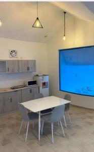 a large screen in a kitchen with a table and chairs at منتجع مطل الريم in Taif