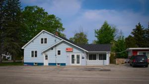 a white building with a sign on it at Maple Leaf Inn & Suites in Kincardine
