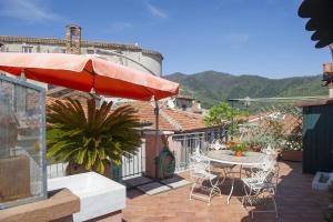 a patio with an umbrella and a table and chairs at Vita Lumiere in Castelnuovo Magra