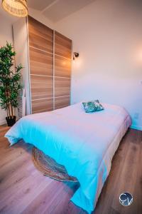 a bedroom with a large bed with a wooden wall at Studio centre-ville (Ecusson) in Nîmes