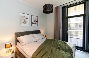 a bedroom with a bed with a large window at Liine apartment 3027 in Pärnu +11 photos